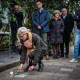 Ina Zijlstra legt de witte roos bij de steen van haar oom Pieter Harkema voor zijn ouderlijk huis. Foto: Suzanne Heikoop/Het Kompas.