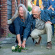 Broer Kees en nicht José leggen samen een witte roos op de struikelsteen voor Jacob van der Knaap, september 2021