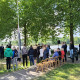 Leerlingen staan om het monument heen na het leggen van de rozen